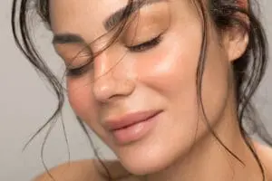Close up studio shot of a beautiful natural woman with freckled skin.